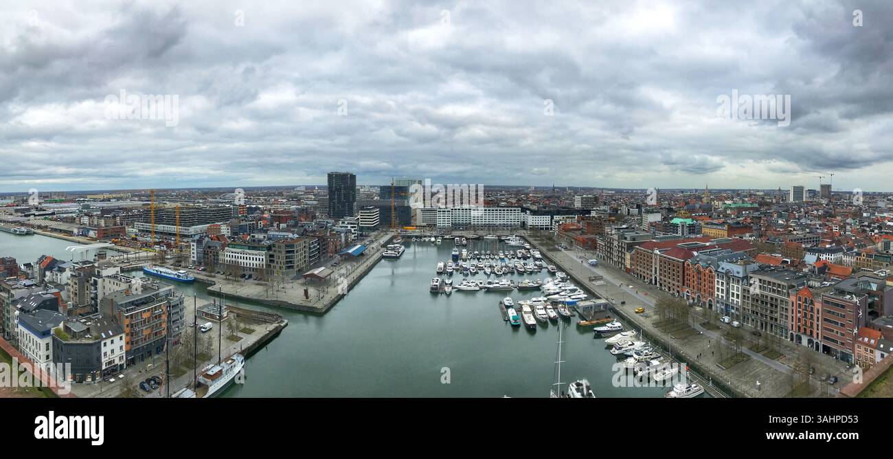Panorama eines Yachthafens mit zahlreichen Booten, die in modernen Gebäuden und bewölktem Himmel angedockt sind, zeigt die städtische Uferentwicklung und die malerische Landschaft Stockfoto