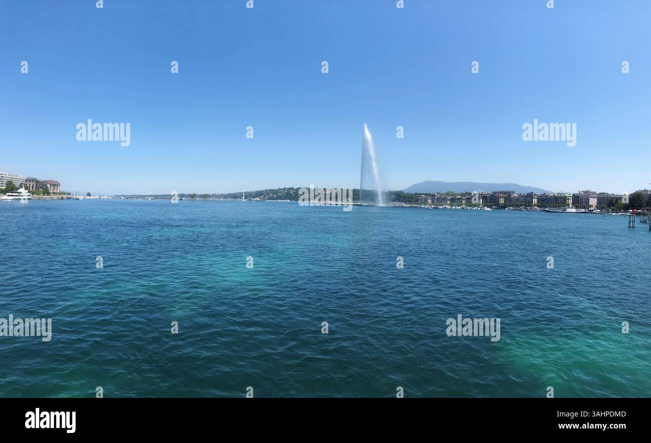 Weitwinkelszene eines malerischen Sees mit einem hohen Brunnen, einer malerischen Umgebung und einem klaren Himmel, der Ruhe und natürliche Schönheit bietet. Stockfoto