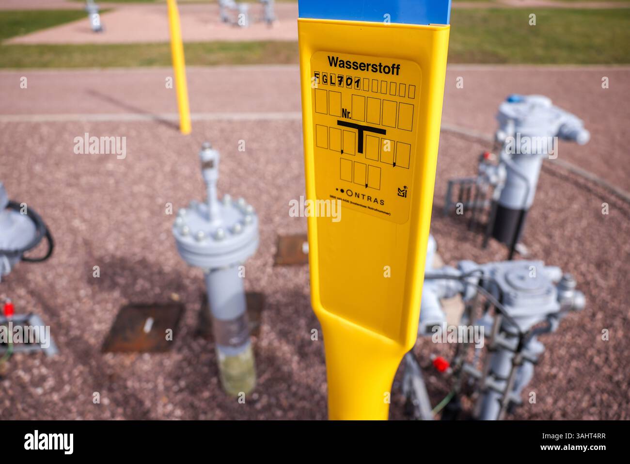 Milzau, Deutschland. April 2025. Ein Schild weist auf die neue Wasserstoffpipeline am Milzau-Netzknoten. Im Rahmen eines realen Labors für die Energiewende wurde hier eine bestehende 25 Kilometer lange Erdgasleitung in Richtung des Chemiestandorts Leuna auf grünen Wasserstoff umgebaut. Im Energiepark Bad Lauchstädt soll zukünftig grüner Wasserstoff aus Windenergie und Elektrolyse erzeugt, unterirdisch gespeichert und von dort aus ins Gasnetz eingespeist werden. Quelle: Jan Woitas/dpa/Alamy Live News Stockfoto