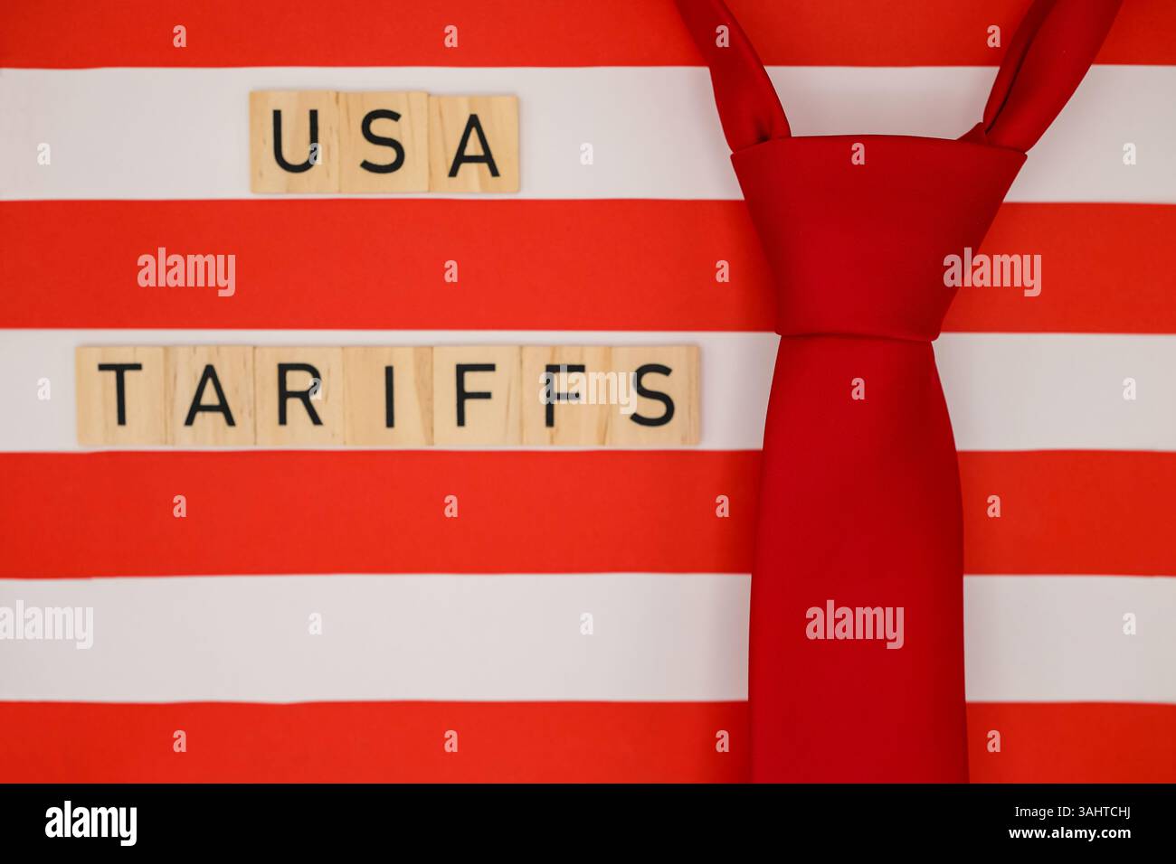 Rote Krawatte auf dem Hintergrund der stilisierten amerikanischen Flagge. Worte „USA Tariffs“. Konzeptdesign für Nachrichten, Analysen oder politische Illustration. Stockfoto