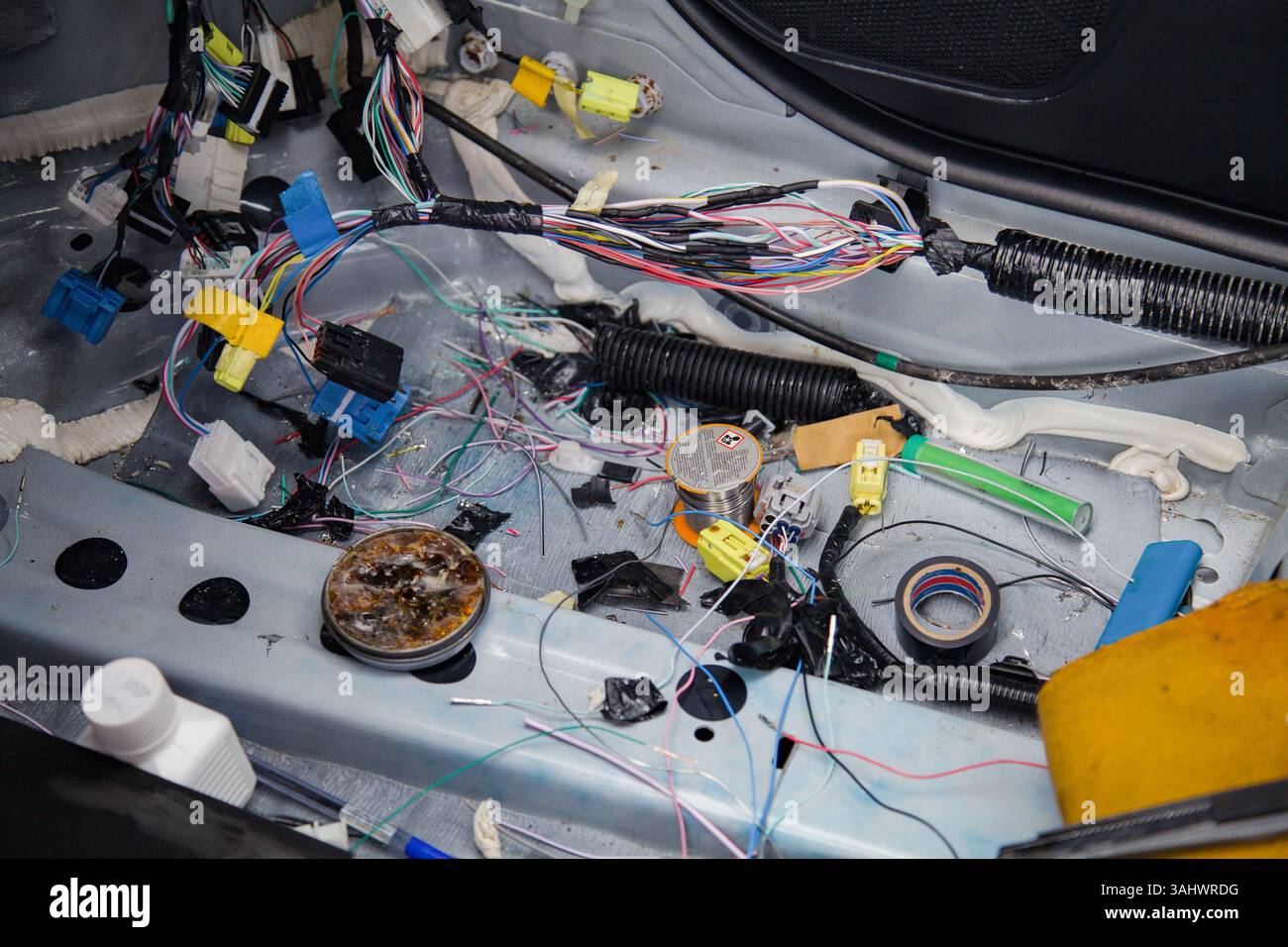 Abisolierzangen, Kolophonium, Isolierband und andere Werkzeuge eines Autolektors, der an einem Austausch von Kabeln in einem Auto arbeitet Stockfoto