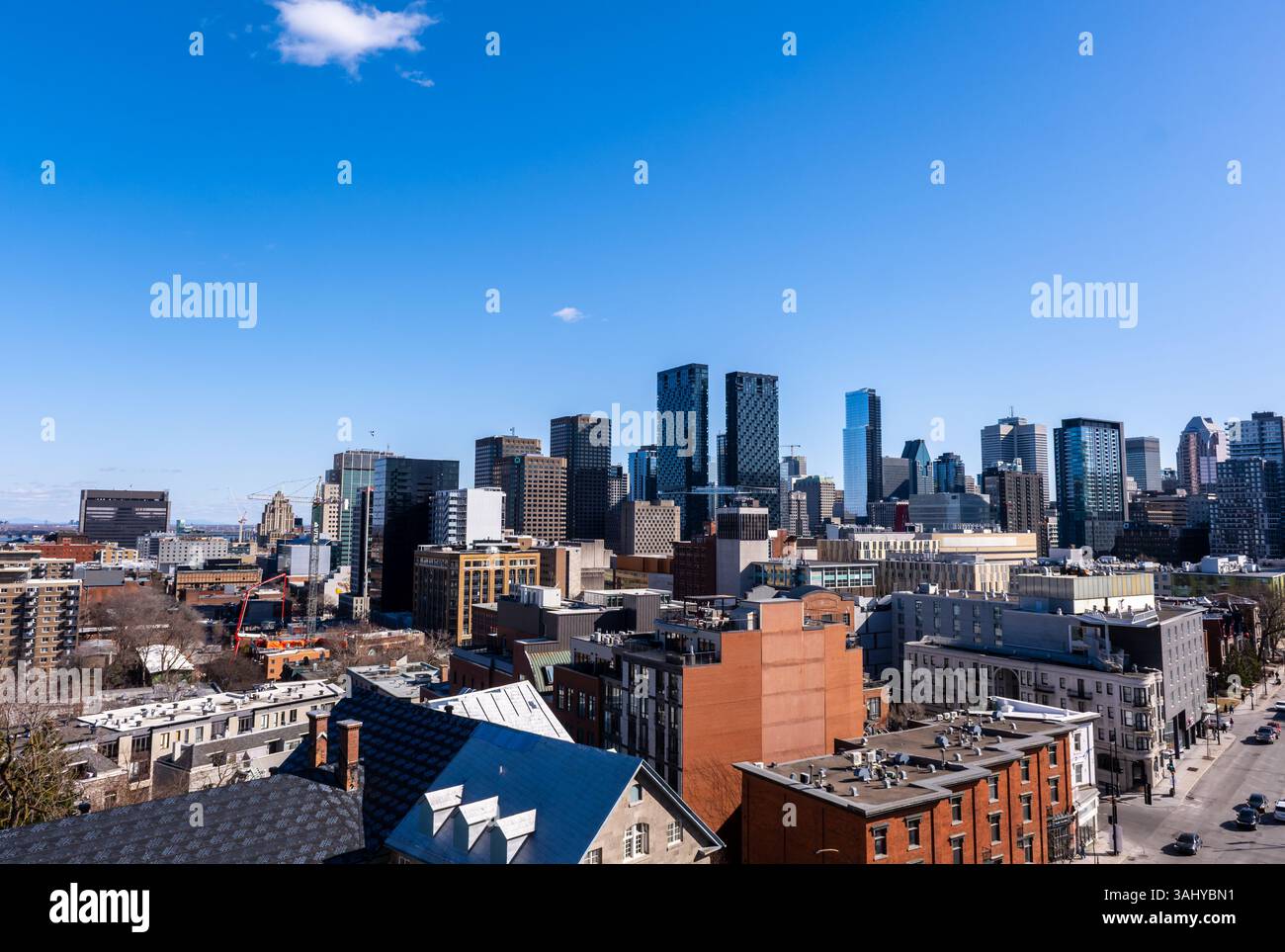 Montreal, Kanada - 4. April 2025: Ein grandioser Blick auf Montreals vielfältige Skyline, die historische Dächer mit modernen Wolkenkratzern unter einer klaren Spitze verbindet Stockfoto