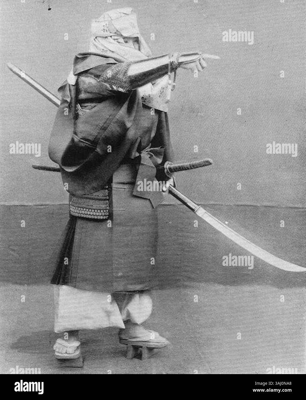 Dieses Foto aus dem Jahr 1895 zeigt einen Yamabushi, einen Kriegermönch aus der Kamakura-Zeit. Unter seinen klerikalen Gewändern trägt die Figur eine Naginata, die die Rolle buddhistischer Mönche in militärischen Konflikten der damaligen Zeit demonstriert. Stockfoto