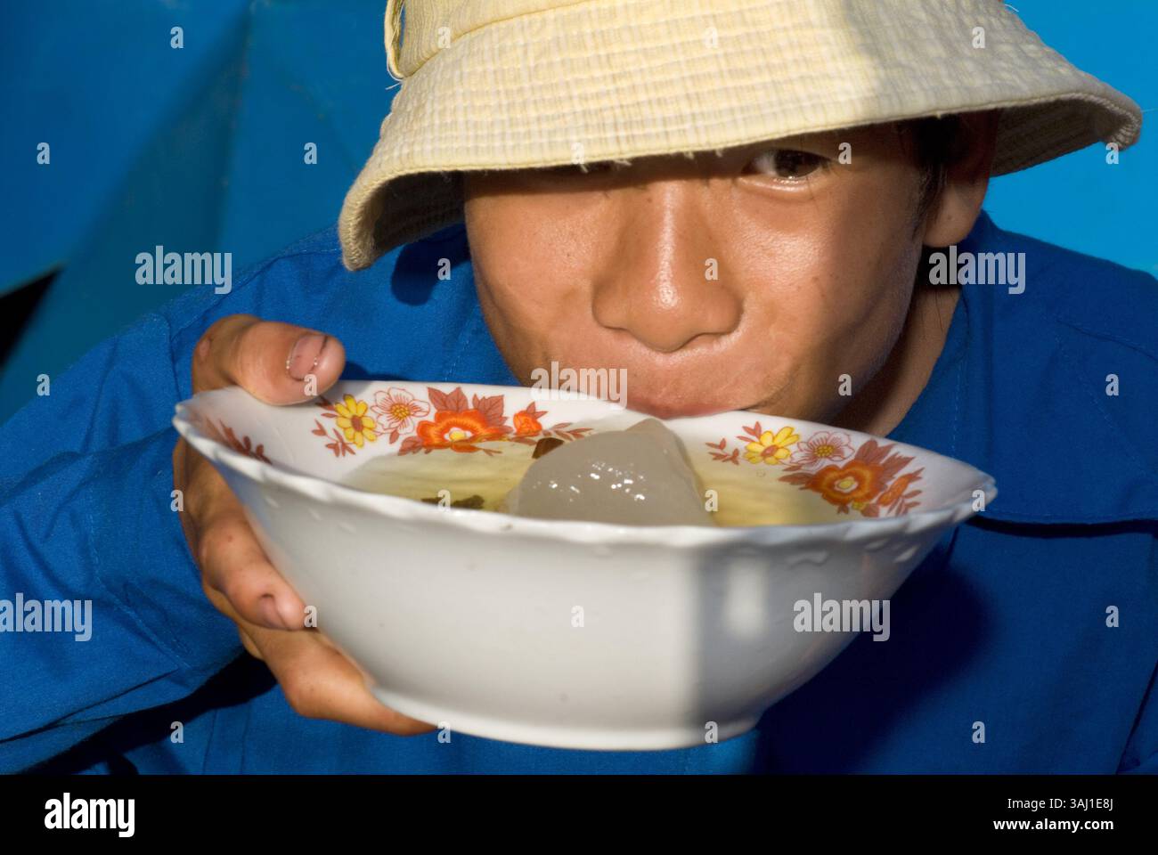 22. Juli 2008 - Vietnam - ein lächelnder vietnamesischer Mann trägt einen vietnamesischen Helm und trinkt Eistee, Porträt, Dien Bien Phu, Vietnam, Asien (Foto: © Sergi Reboredo via ZUMA Wire) Stockfoto