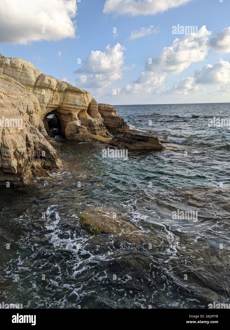 Meereshöhlen in der Nähe von Peyia, Zypern, wo Wellen und Wind zeitlose Bögen in die Klippen der Küste geformt haben. Stockfoto