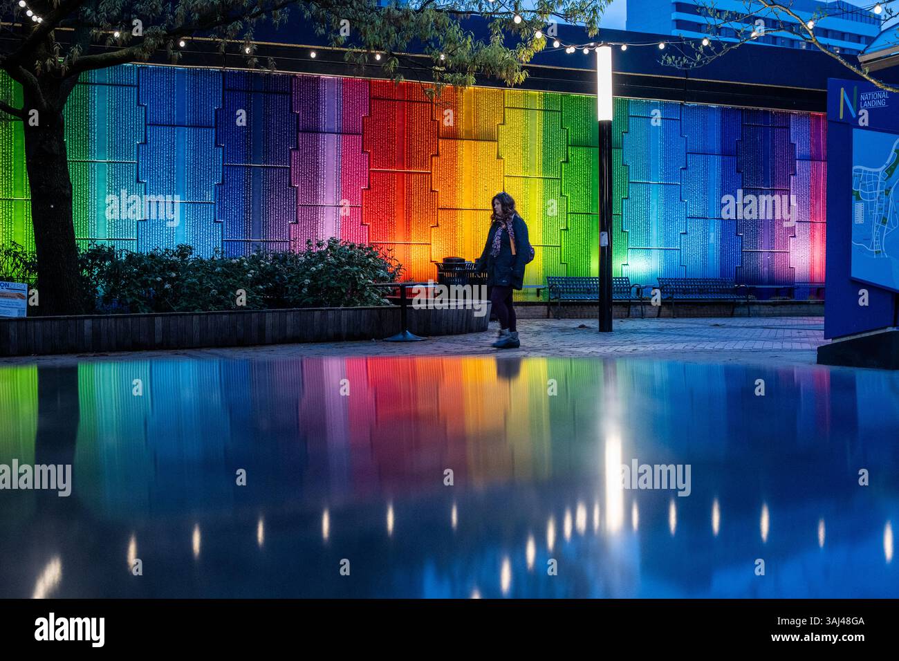 CRYSTAL CITY, Virginia – das Harmony Mural zeigt ein 23-farbiges Spektrum-Design auf 115 m Wandfläche am Crystal City Metro Station plaza. Das 2021 von der Künstlerin Lisa Marie Thalhammer aus Washington DC geschaffene Spritzlackkunstwerk wurde vom National Landing Business Improvement District im Rahmen eines Auswahlverfahrens in Auftrag gegeben. Das Wandbild wurde entworfen, um Pendlern durch Farbpsychologie therapeutische Vorteile zu bieten und gleichzeitig als Meilenstein für die Umwandlung des Gebiets in National Landing zu dienen. Die Installation fiel zeitlich mit den Bemühungen zur Wiederherstellung nach der Pandemie und dem HQ2 von Amazon zusammen Stockfoto