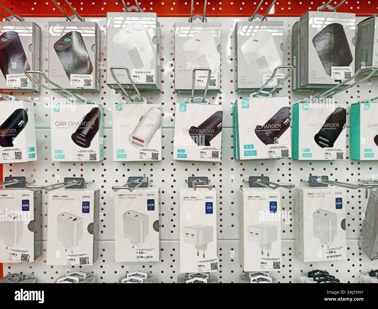 Verschiedene elektronische Kfz- und Wandladegeräte im Ladenregal. Stockfoto