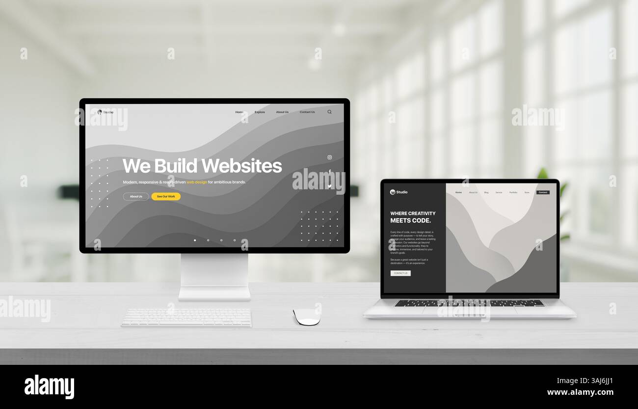 Kreativer Arbeitsbereich mit zwei Webstudio-Designs auf Bildschirm und Laptop, moderne Schreibtischeinrichtung mit weicher Büroumgebung im Hintergrund Stockfoto