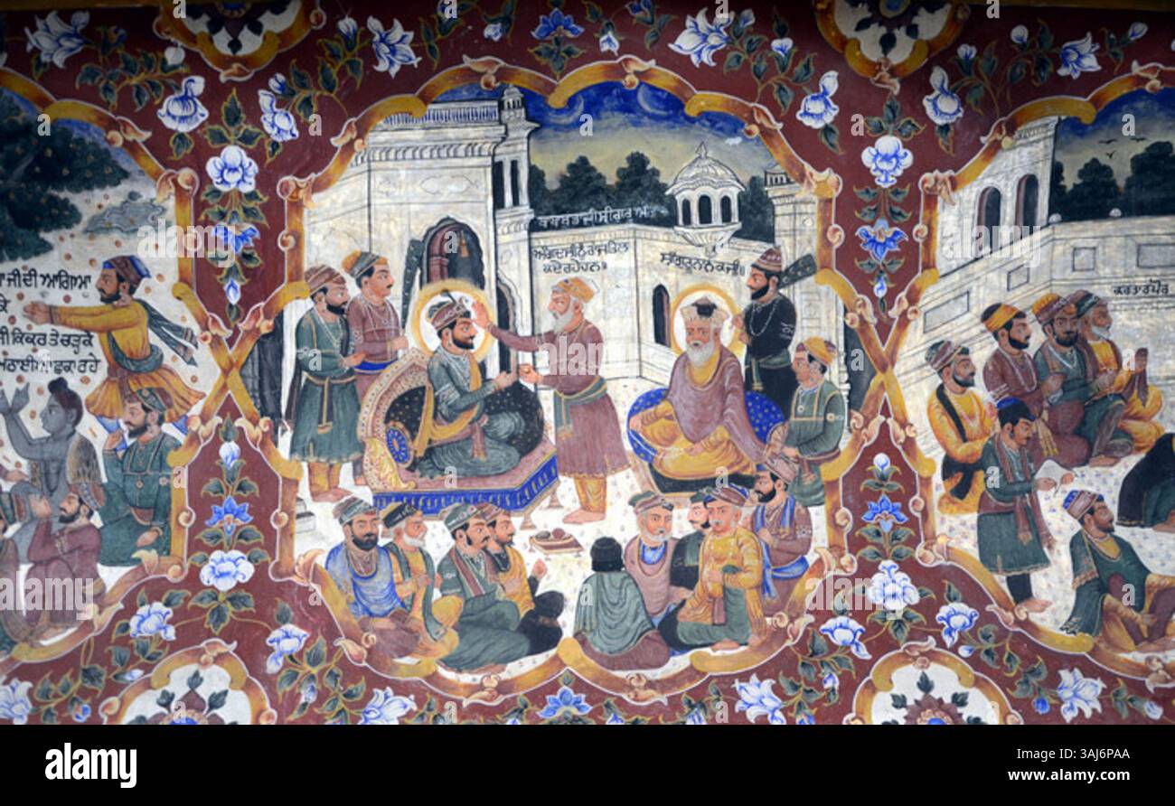 Das Fresko zeigt die Zeremonie des Guru Angad Dev, der 1521 in Kartarpur Guruship von Guru Nanak erhielt, was einen wichtigen Moment in der Geschichte der Sikh veranschaulicht. Das Kunstwerk, das von den Künstlern Gian Singh Naqqash, Jaimal Singh Naqqash, Mehtab Singh Naqqash und Hukum Singh gemalt wurde, zeigt die Weitergabe von Führung und Gurus Lehren an Bhai Lehana, der in Guru Angad umbenannt wurde. Stockfoto