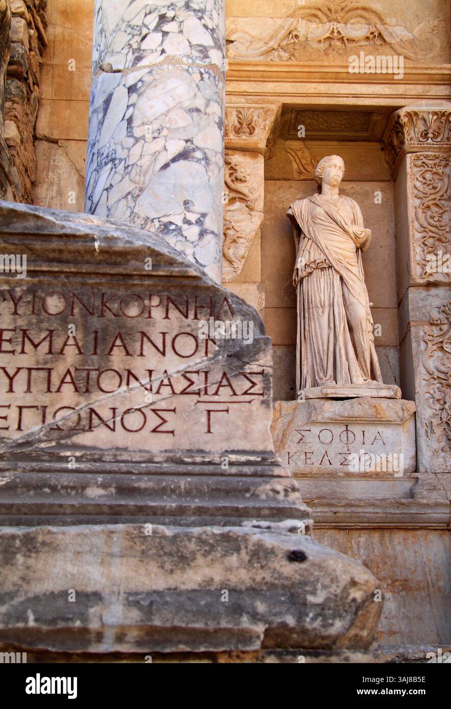 Türkei, Kusadasi. Die archäologische Stätte von Ephesus. Inschrift und Marmorstatue in der Fassade der Celsius-Bibliothek. UNESCO-Weltkulturerbe. Stockfoto