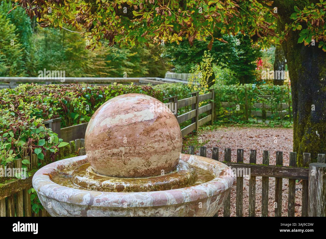 Brunnen mit einer Marmorkugel im Garten der Kugelmühle, Deutschland, Bayern, Almbachklamm Stockfoto