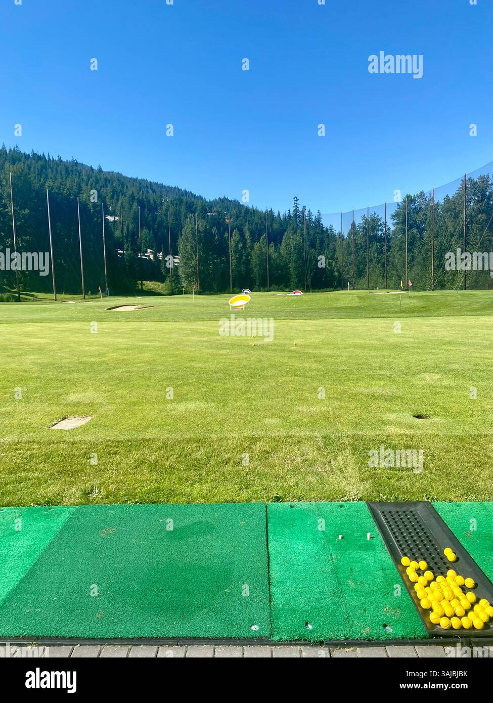 Sonniger Nachmittag in der Forest-Backed Driving Range - Smartphone-aufgenommenes Stockfoto