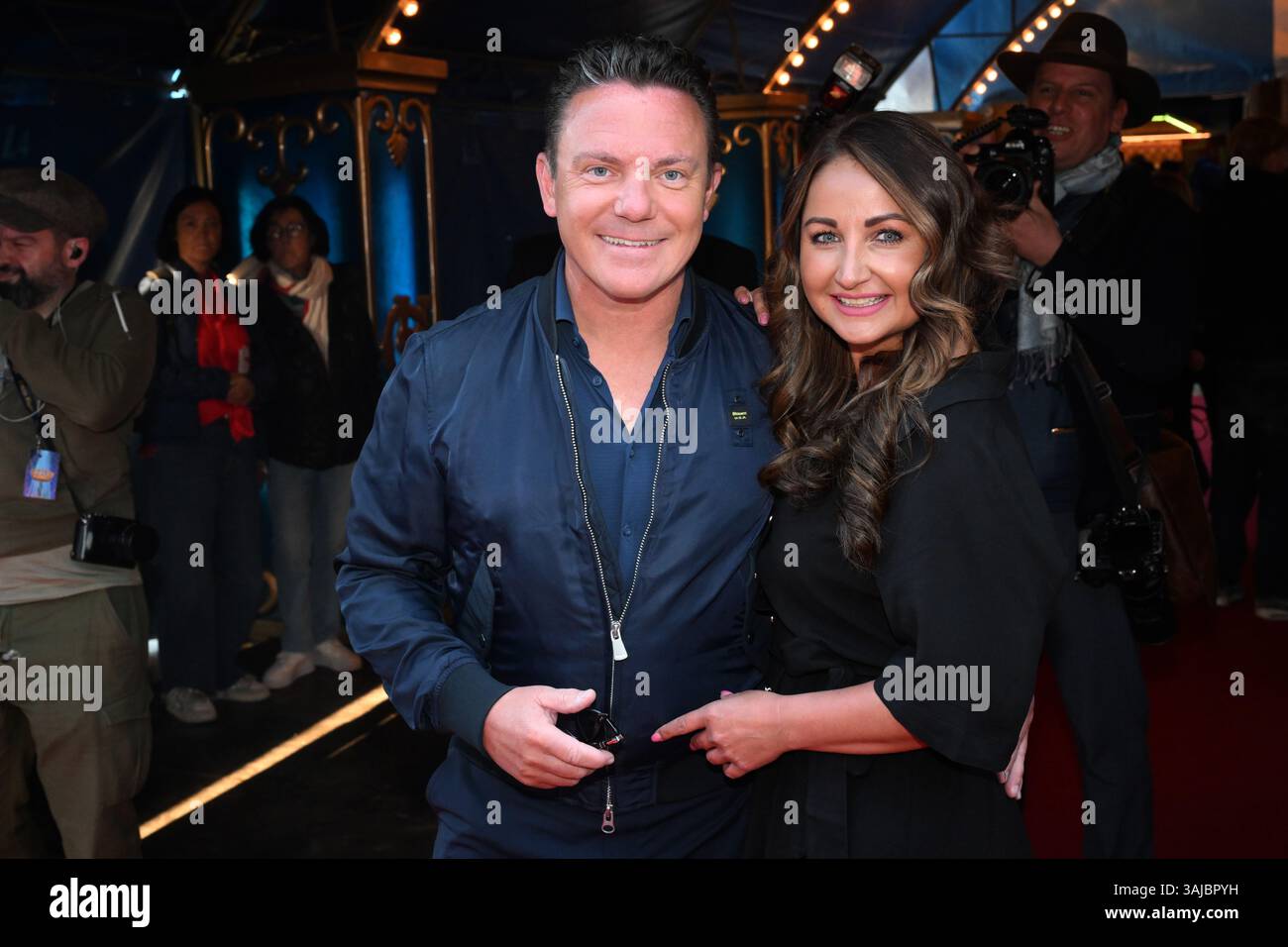 München, Deutschland. April 2025. Sänger Stefan Mross und Eva Luginger kommen zur Premiere der Farbenspiel Gold Edition im neuen Zirkuszelt des Circus Krone auf der Theresienwiese. Quelle: Felix Hörhager/dpa/Alamy Live News Stockfoto München, Deutschland. April 2025. Sänger Stefan Mross und Eva Luginger kommen zur Premiere der Farbenspiel Gold Edition im neuen Zirkuszelt des Circus Krone auf der Theresienwiese. Quelle: Felix Hörhager/dpa/Alamy Live News Stockfoto