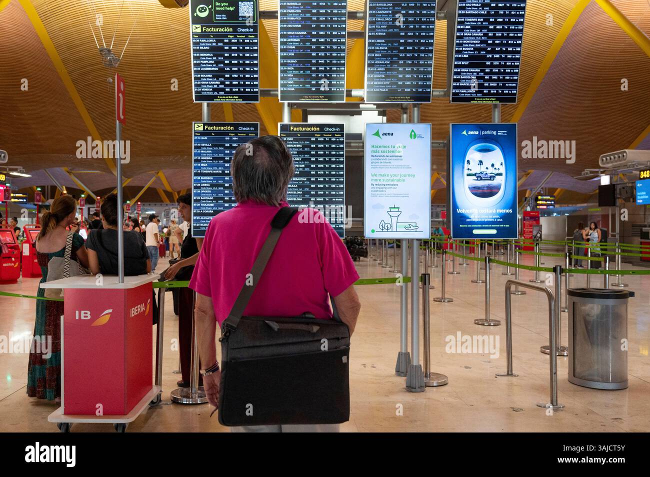 Madrid, Spanien. April 2025. Ein Reisender schaut auf einen Check-in-Bildschirm der Fluggesellschaft in der belebten Abflughalle von Adolfo Suárez Madrid-Barajas Terminal 4 des größten internationalen Flughafens Spaniens. (Foto: Xavi Lopez/SOPA Images/SIPA USA) Credit: SIPA USA/Alamy Live News Stockfoto