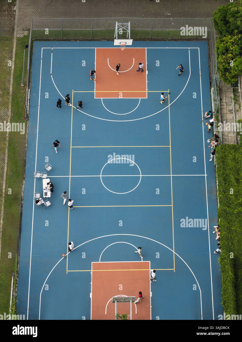 Luftaufnahme eines Menschen, der auf dem Basketballfeld auf der Straße in der städtischen Umgebung spielt Stockfoto
