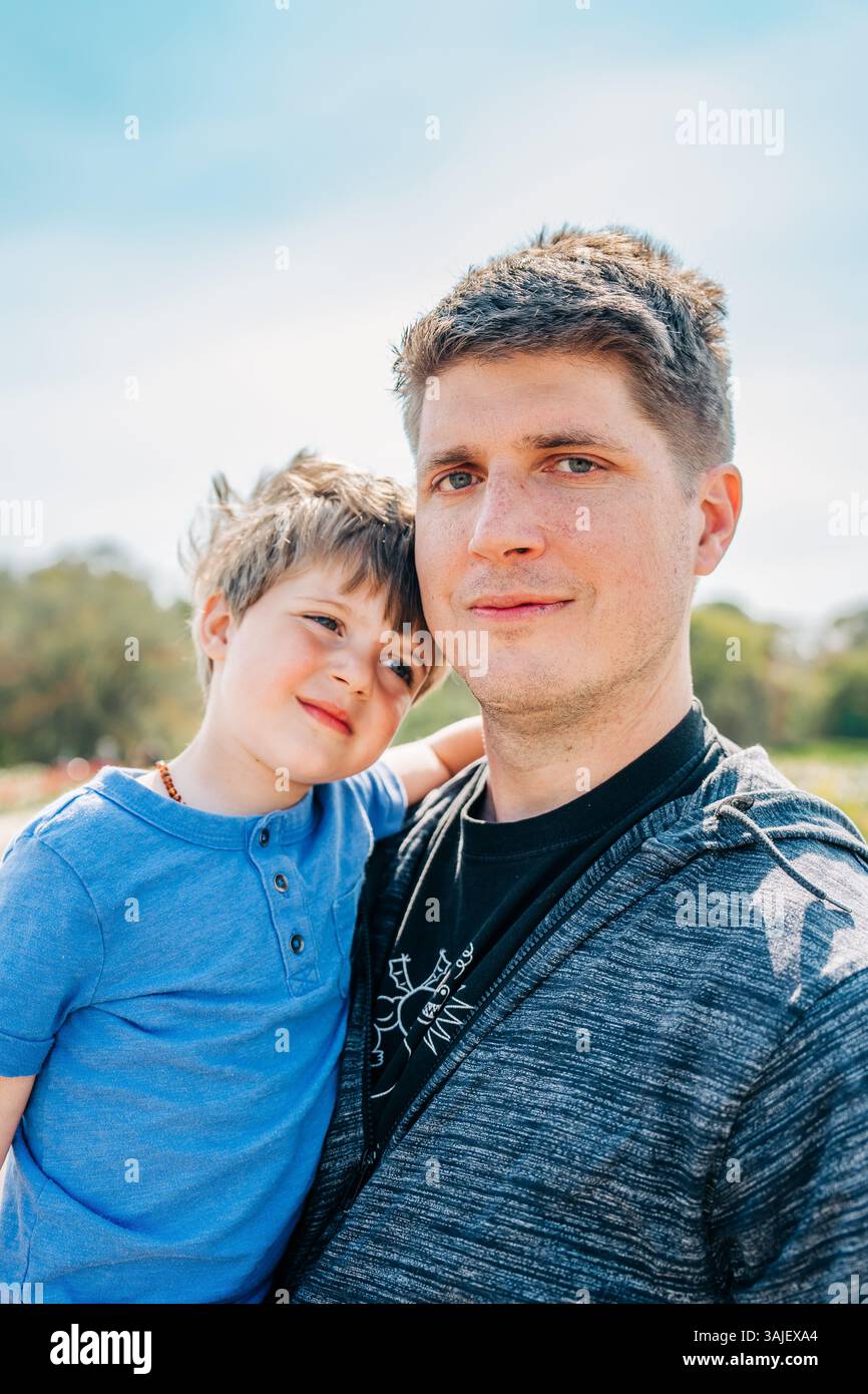Vater und Sohn teilen sich einen warmen Moment draußen im Sonnenlicht Stockfoto