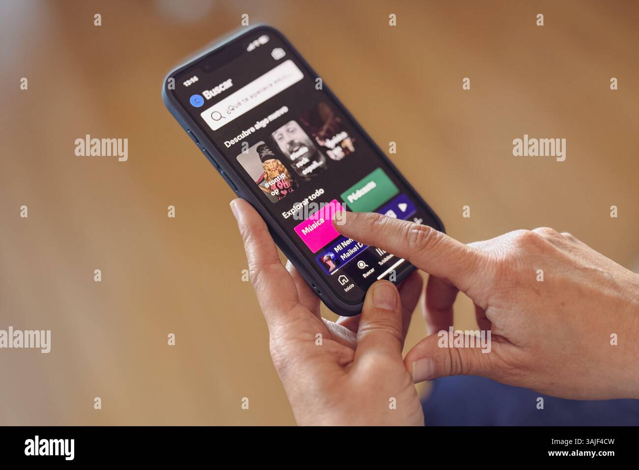 Nahaufnahme von Frauenhänden mit der Spotify App auf dem iPhone Stockfoto