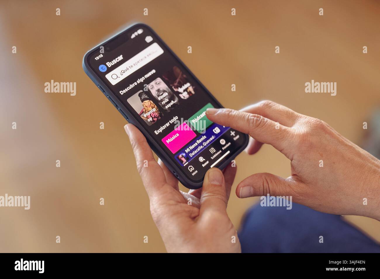 Nahaufnahme von Frauenhänden mit der Spotify App auf dem iPhone Stockfoto
