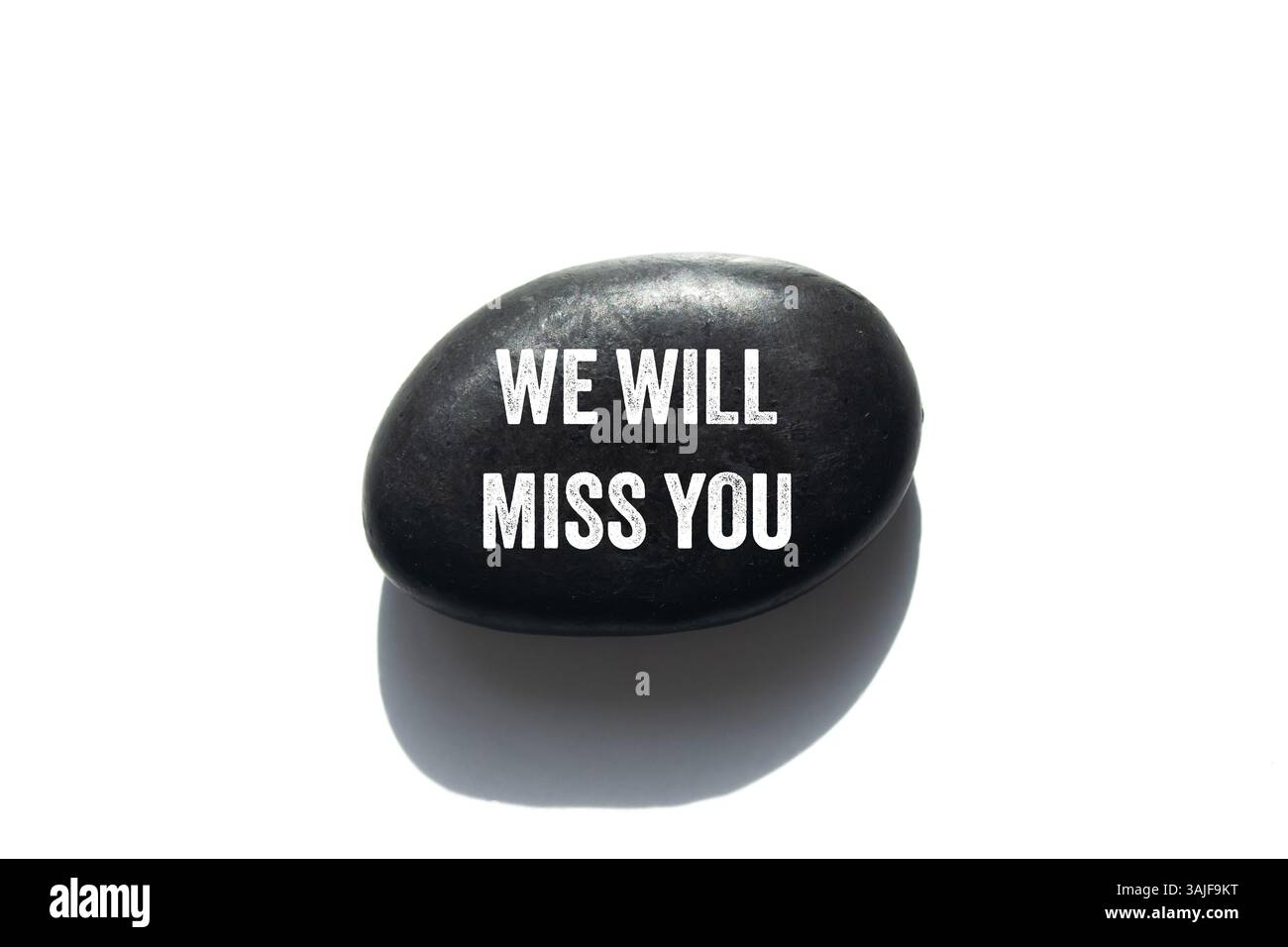 Wir werden Ihre Nachricht auf schwarzem Stein auf weißem Hintergrund vermissen. Konzeptionell werden wir dich vermissen Symbol. Kopierbereich. Stockfoto