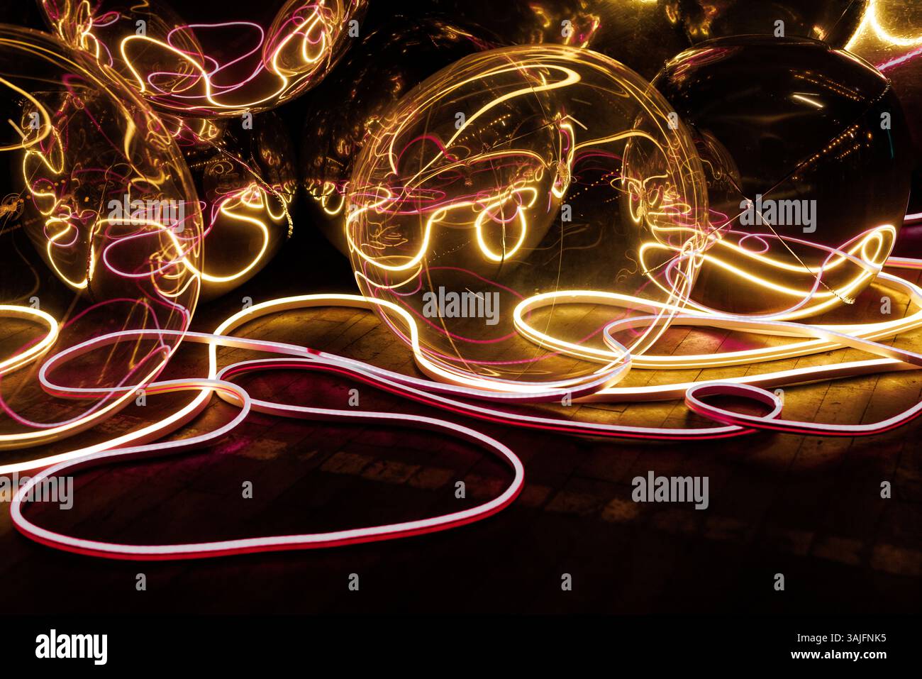 Ein Haufen glühender Kugeln sind in einer Reihe angeordnet. Die Kugeln sind Neon Stockfoto