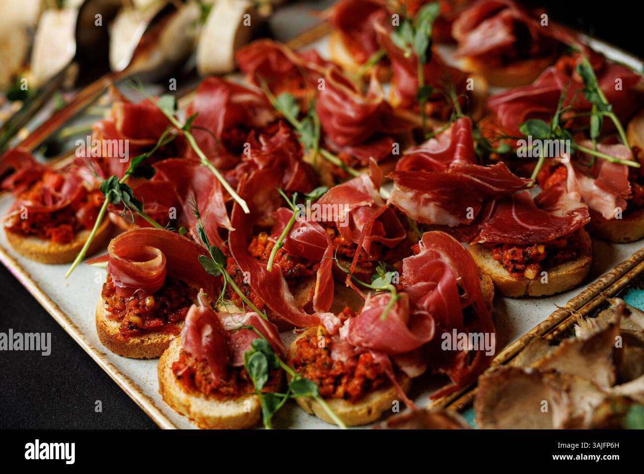 Ein Tablett mit Fleisch und Gemüse mit grüner Garnitur. Das Fleisch wird in Scheiben geschnitten und auf einem weißen Teller angeordnet Stockfoto