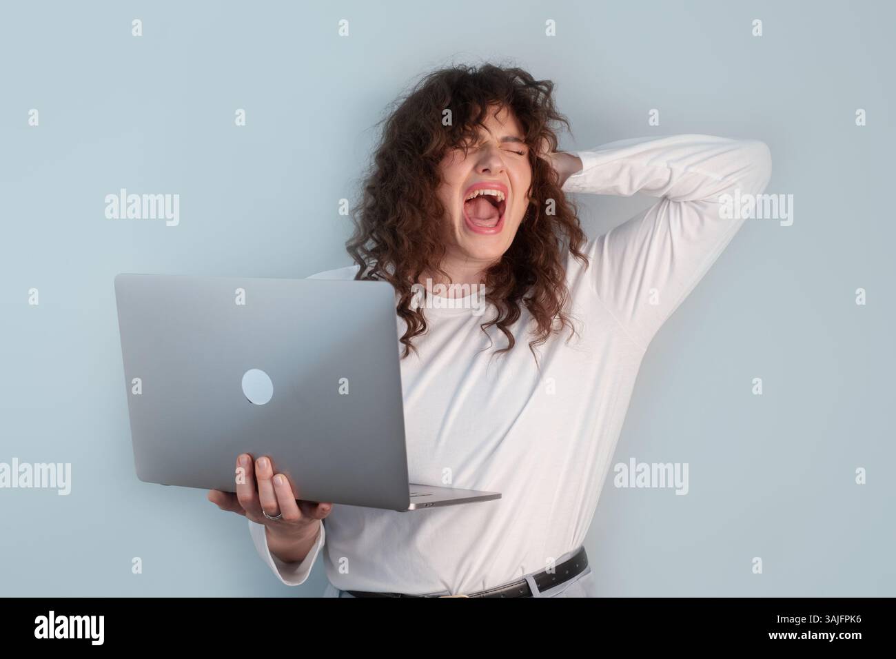Arbeitsplatzstresskonzept Frau, die sich schwer tut, Karriere und Privatleben miteinander in Einklang zu bringen, sitzt am Schreibtisch mit besorgter Ausdruckskraft. Stockfoto