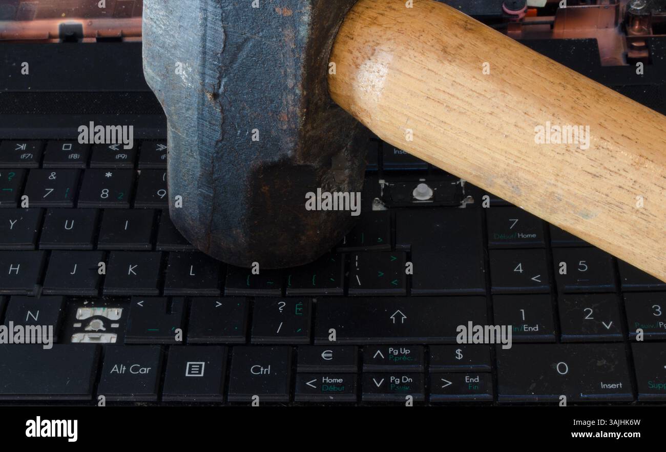 Vorschlaghammer trifft auf Computertastatur Stockfoto