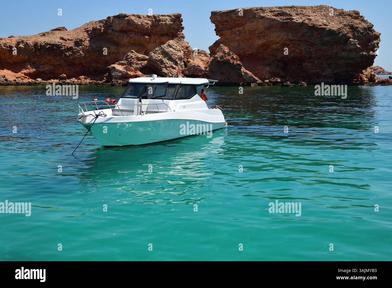 Golf von Oman, Ad Daymaniyat Inseln. Verankertes weißes Boot. Sultanat Oman Stockfoto