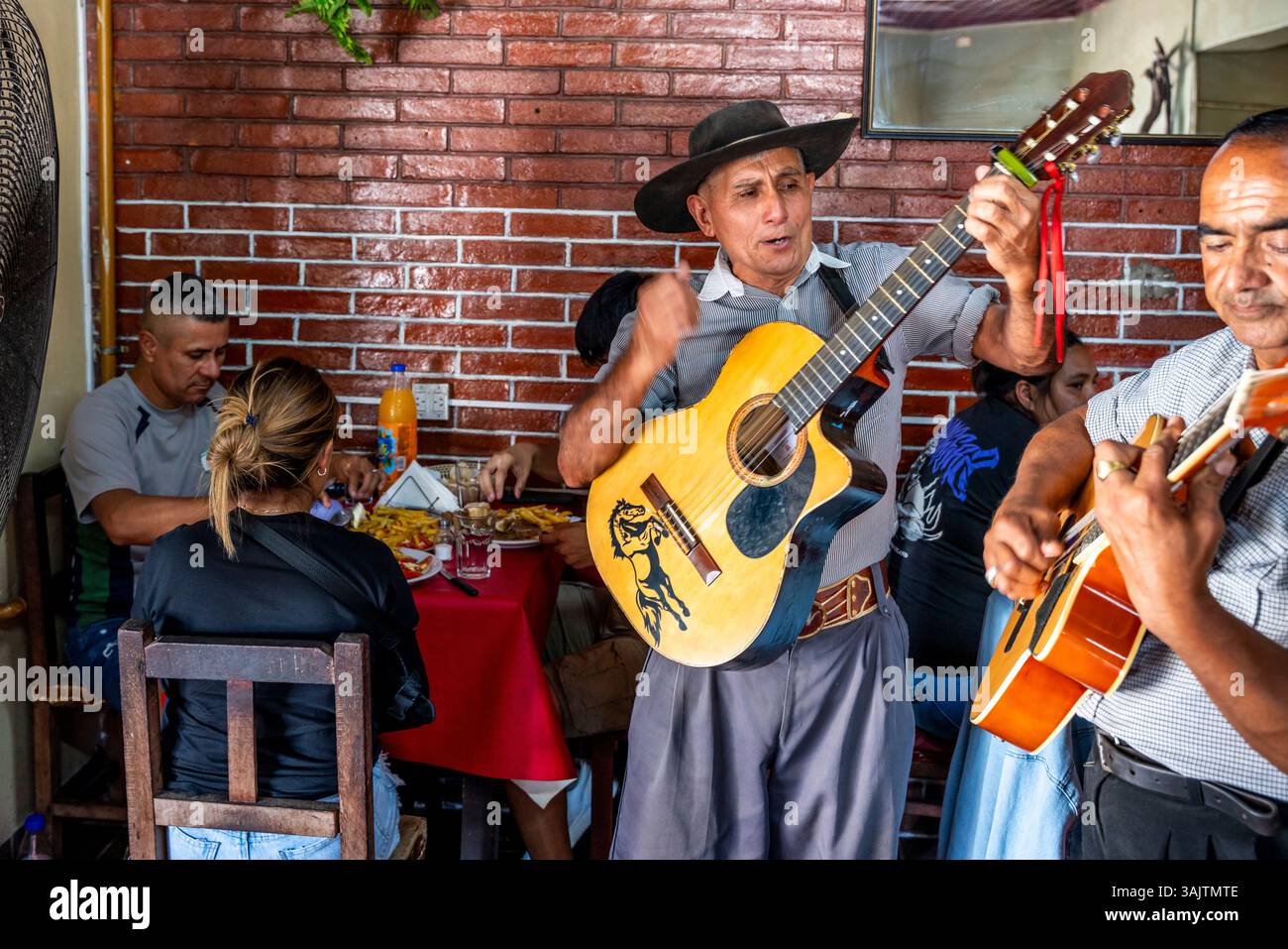Traditionelle argentinische Musiker singen und spielen Gitarre für Restaurant Diners in der Stadt Salta, Provinz Salta, Argentinien. Stockfoto