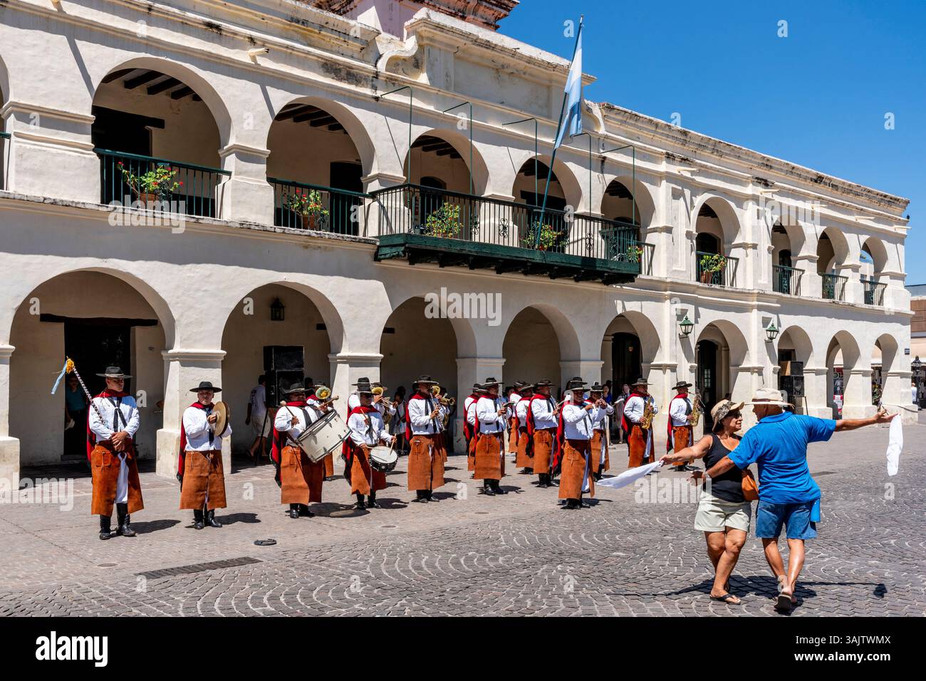 Ein argentinisches Paar Tanz auf dem 9. Juli Platz, als Eine Gaucho Band während der zweimonatlichen Zeremonie zum Wachwechsel in Salta, Argentinien spielt. Stockfoto
