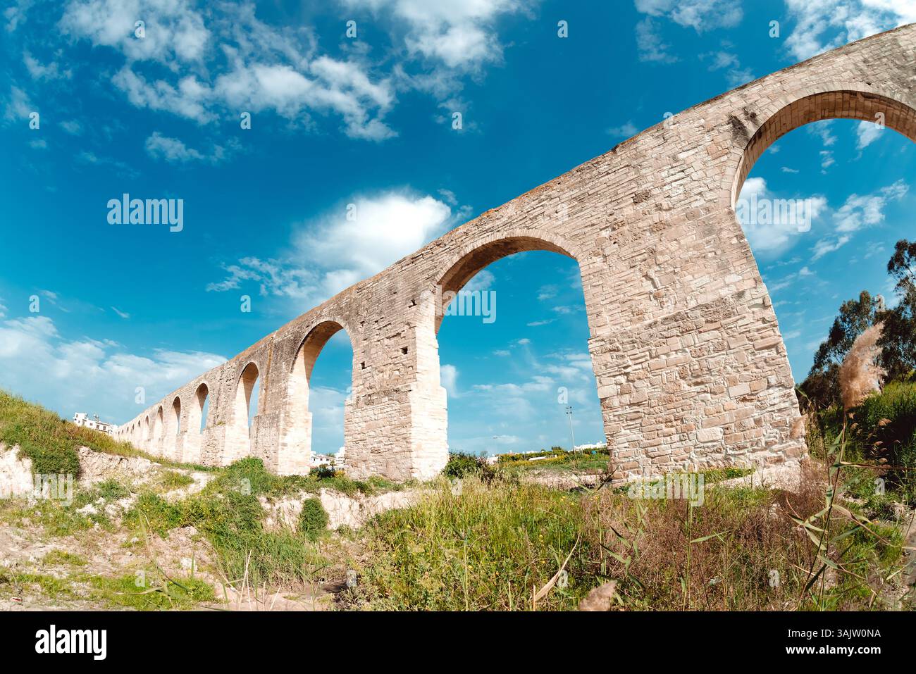 Kamares Steinaquädukt erhebt sich gegen azurblauen Himmel und enthüllt historische technische Meisterwerke aus der zyprischen Landschaft mit dramatischem Sonnenlicht Stockfoto