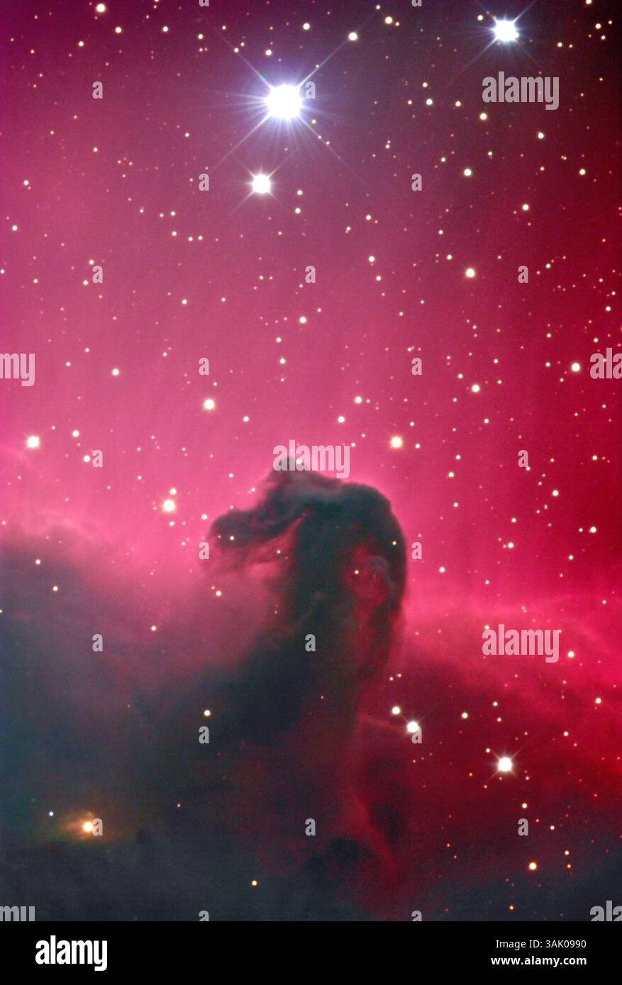 Horsehead-Nebel. Der Pferdekopf ist die Silhouette der dunklen Staubwolke Barnard 33 (B33) gegen den hellen Emissionsnebel IC 434. IC 434 strahlt Licht aus, da das darin enthaltene Wasserstoffgas durch Strahlung eines nahe gelegenen heißen jungen Sterns ionisiert wird. Der Nebel liegt etwa 1500 Lichtjahre entfernt im Sternbild Orion. Er ist Teil einer riesigen Wolke aus Gas und Staub, dem Orion-Komplex, einer aktiven Sternirtenregion. Stockfoto