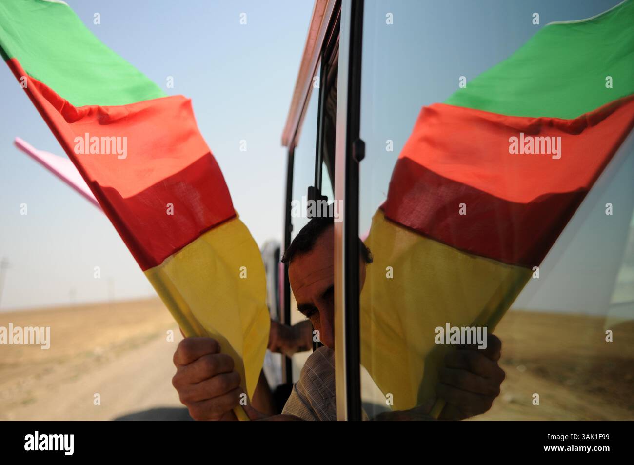18. Oktober 2009 - Zakho, Irak - Ein Anhänger der PKK führt die kurdische Flagge, während er an die Grenze zur Türkei fährt. Acht kurdische Rebellen sind vom Irak aus in die Türkei eingedrungen, um sich als Zeichen der Unterstützung für Friedensbemühungen aufzugeben. Die PKK-Militanten verließen ihre Zuflucht in den Qandil-Bergen und wurden von Flüchtlingen aus dem Flüchtlingslager Makmur im Irak begleitet, bevor sie in die Türkei einreisten. (Kreditbild: © Kamaran Najm/ZUMA Press) Stockfoto