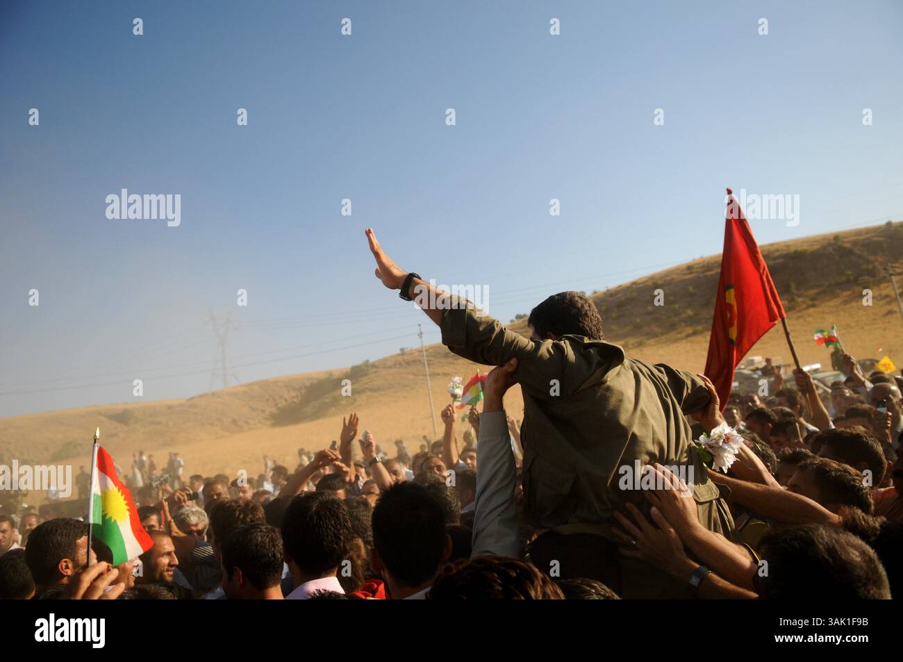18. Oktober 2009 - Zakho, Irak - Ein PKK-Guerilla wird von irakischen kurdischen Unterstützern hochgehalten. Acht kurdische Rebellen sind vom Irak aus in die Türkei eingedrungen, um sich als Zeichen der Unterstützung für Friedensbemühungen aufzugeben. Die PKK-Militanten verließen ihre Zuflucht in den Qandil-Bergen und wurden von Flüchtlingen aus dem Flüchtlingslager Makmur im Irak begleitet, bevor sie in die Türkei einreisten. (Kreditbild: © Kamaran Najm/ZUMA Press) Stockfoto