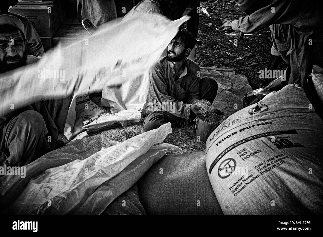 23. Mai 2009 - Peshawar, Pakistan - Verteilung von Nahrungsmitteln im Lager Jalozai, Peshawar, Heimat von fast 100.000 Flüchtlingen aus der vom Konflikt betroffenen nordwestlichen Malakand-Division Pakistans. Rund 3 Millionen Flüchtlinge sind aus dem SWAT-Tal gegossen, als die pakistanische Armee nach dem Scheitern eines Friedensabkommens Anfang Mai 2009 eine massive Operation zur Eliminierung der Taliban-Militanten startete. Beamte des Roten Kreuzes, die seit Beginn der Kämpfe ihren ersten Besuch im pakistanischen SWAT-Tal machten, sagten, dass Zivilisten im Nordwesten dringend Hilfe benötigen. Häuser haben kein fließendes Wasser, keine Energie und Nahrung ist in der Gegend knapp. Stockfoto