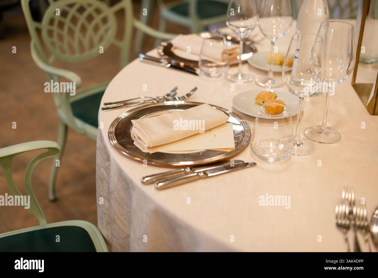 Schön gestalteter Esstisch mit Besteck, Gläsern und Servietten, damit Gäste ein köstliches Essen zusammen genießen können. Stockfoto
