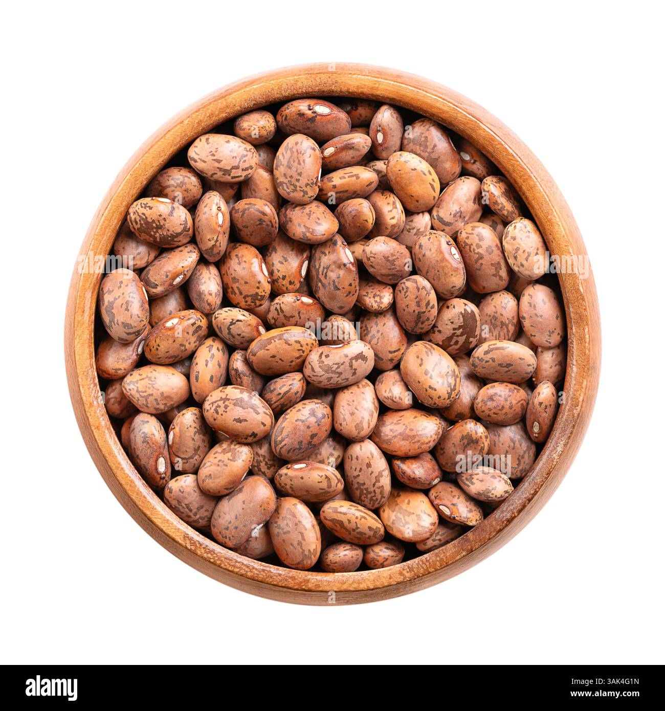 Pinto Bohnen in einer Holzschale. Getrocknete Sorte gewöhnlicher Bohnen, Phaseolus vulgaris. Eine Art Bohnen, die braun sind und rötlich-braune Flecken haben. Stockfoto