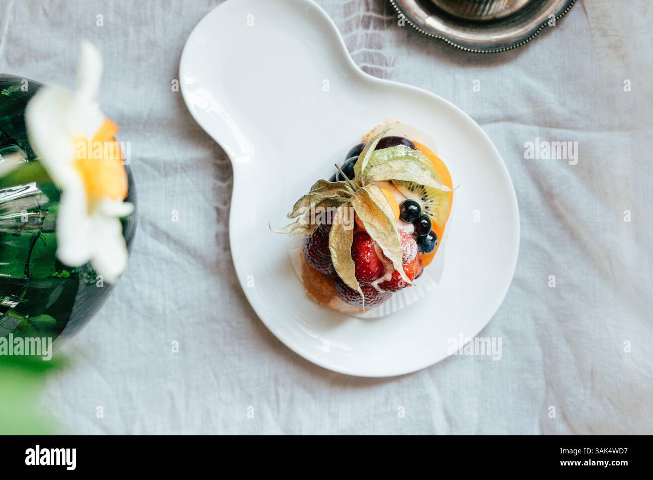 Ein farbenfrohes Dessert bietet frische Erdbeeren, Heidelbeeren und andere Früchte, die elegant angeordnet sind. Das einzigartige Design der Platte ergänzt das lebendige h Stockfoto