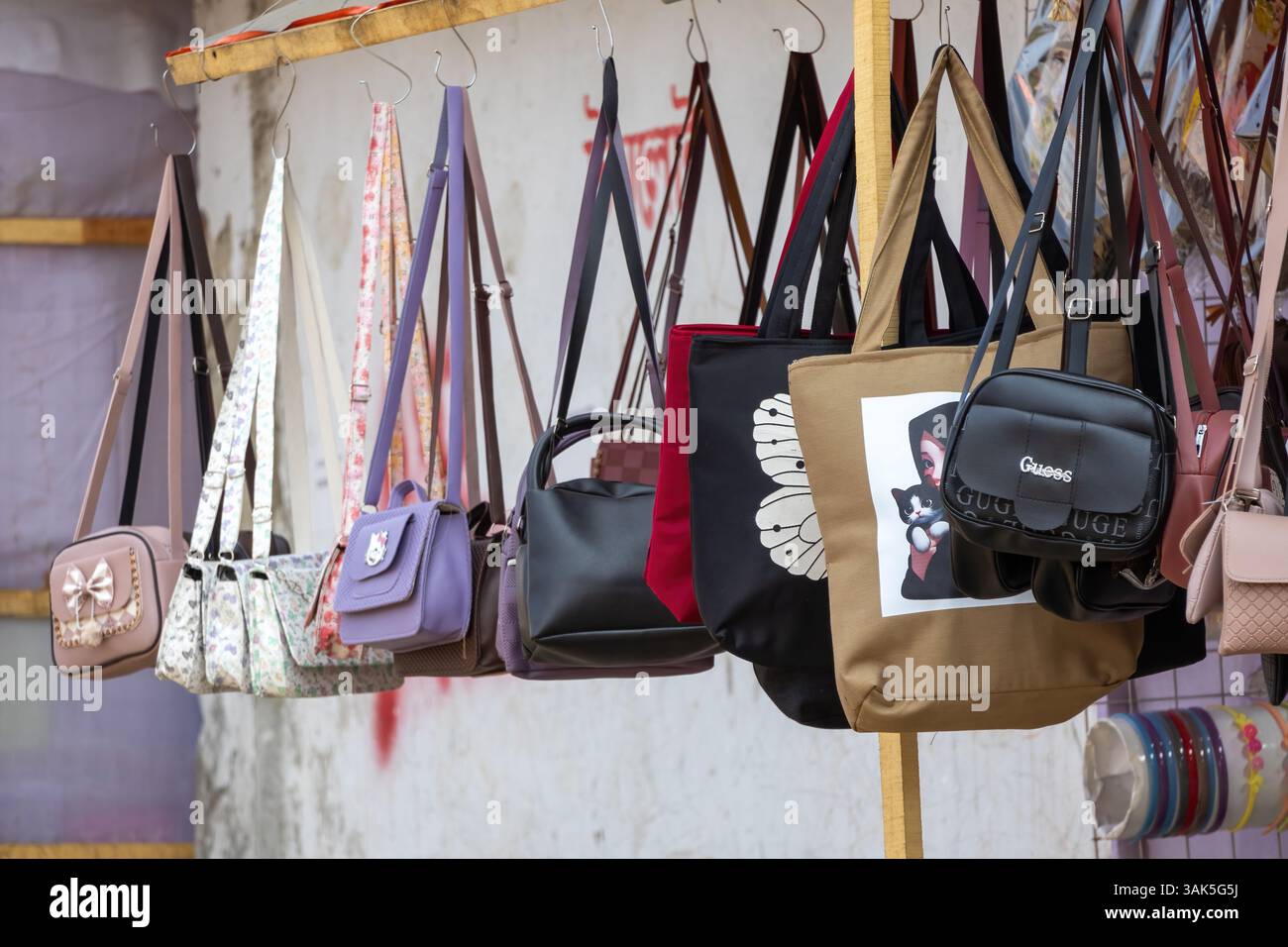 Viele schöne Schultertaschen und Geldbörsen für Frauen hängen am 23. Februar 2025 in einem Messeladen in Kishoreganj, Bangladesch, zum Verkauf. Stockfoto