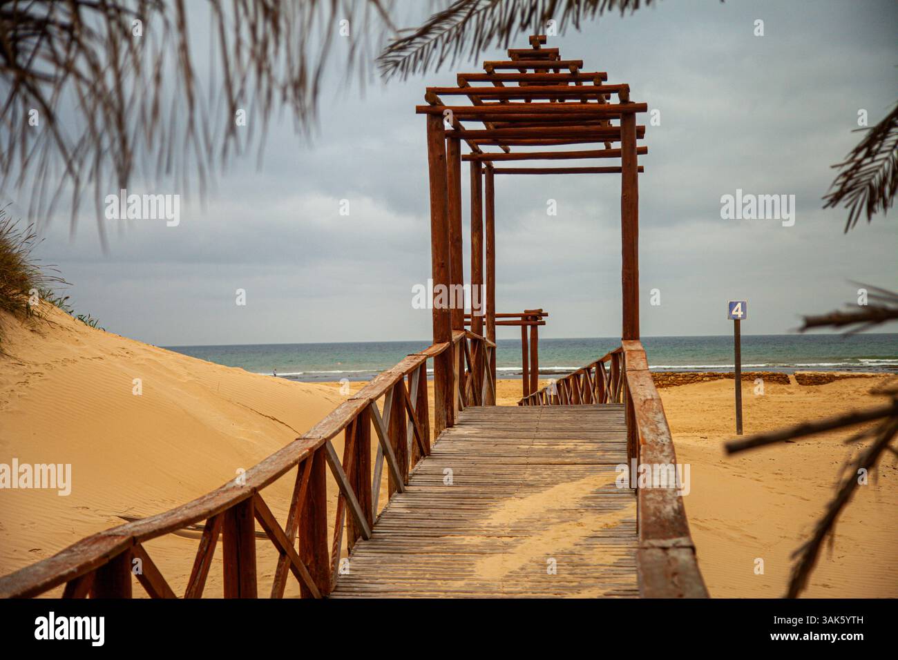 Holzsteg am tropischen Sandstrand Stockfoto