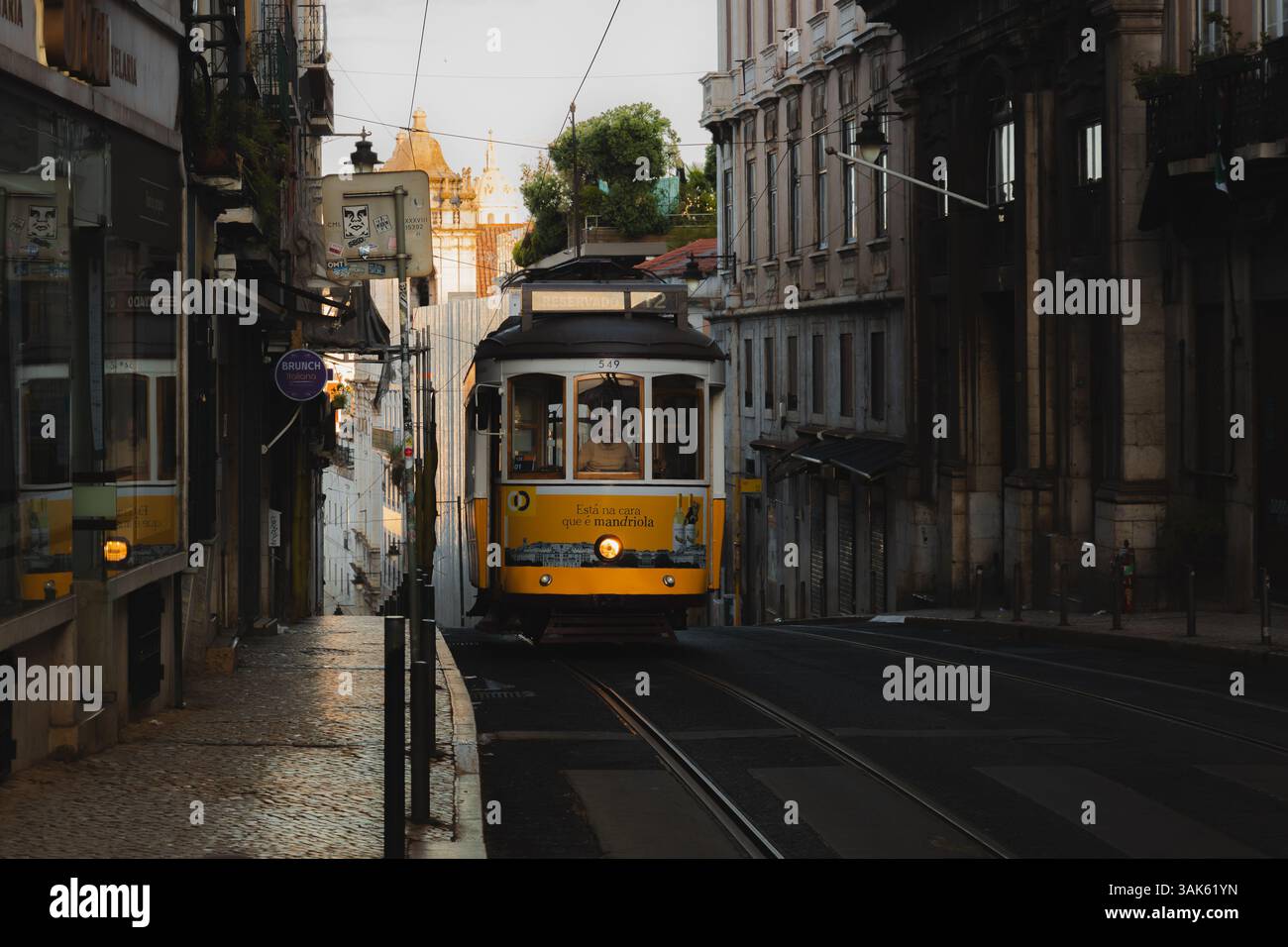 Lissabon, Portugal - 15. Juli 2024: Straßenbahn 12 fährt durch eine historische Straße in Bairro Alto, Lissabon, und fängt den alten Charme und das pulsierende Stadtleben dieser Stadt ein Stockfoto