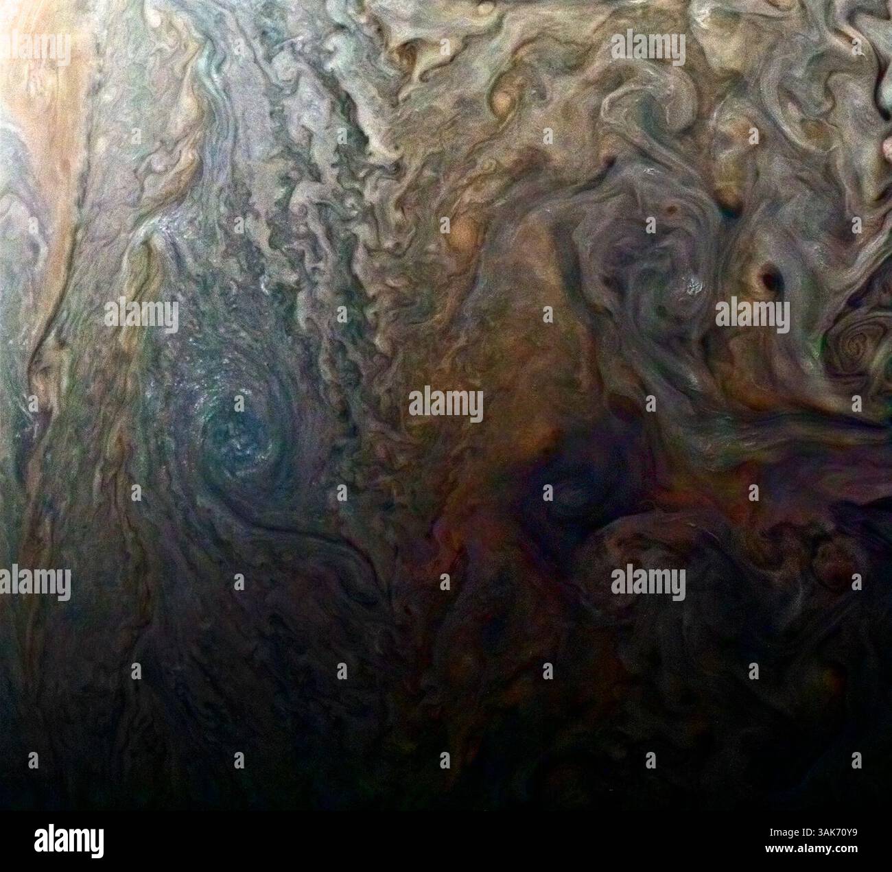 März 2017 - Juno-Atmosphäre - dieses Farbbild eines geheimnisvollen dunklen Flecks auf dem Jupiter scheint eine jovianische „Galaxie“ wirbelnder Stürme zu enthüllen. Juno akquirierte dieses JunoCam-Bild am 2. Februar 2017 um 5:13 Uhr PDT (8:13 Uhr EDT) in einer Höhe von 9.000 Meilen (14.500 km) über den Wolkenspitzen des Riesenplaneten. Dieses öffentlich ausgewählte Ziel wurde einfach mit dem Titel „Dark Spot“ bezeichnet. In bodenbasierten Bildern war es schwierig zu erkennen, dass es sich um einen dunklen Sturm handelt. Der Bürgerwissenschaftler Roman Tkachenko hat die Farbe verbessert, um die Details des Sturms und der umliegenden Wolken hervorzuheben. Genau südlich des dunklen Staus Stockfoto