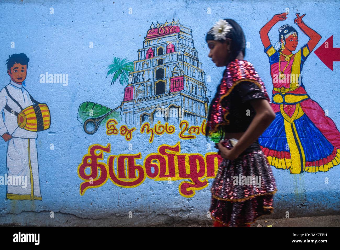 Das Chariot Festival im Sri Muttumariamman Hindu Temple in Sri Lanka Eine Tänzerin spaziert am 11. April 2025 an einer bemalten Wand vorbei vor dem Chariot Festival im Sri Muttumariamman Hindu Temple in Moratuwa, Sri Lanka. Das Festival ist ein lebendiges religiöses Ereignis, das einheimische Anhänger und Besucher gleichermaßen anzieht. Das Festival wird jährlich veranstaltet und ehrt die hinduistische Göttin Mariamman, die für ihre Schutzkräfte und Heilkräfte verehrt wird. Im Mittelpunkt der Feier steht die zeremonielle Prozession eines reich geschmückten Wagens, der die Gottheiten-Statue durch die Straßen trägt, begleitet von traditioneller Musik, Trommeln und Stockfoto Das Chariot Festival im Sri Muttumariamman Hindu Temple in Sri Lanka Eine Tänzerin spaziert am 11. April 2025 an einer bemalten Wand vorbei vor dem Chariot Festival im Sri Muttumariamman Hindu Temple in Moratuwa, Sri Lanka. Das Festival ist ein lebendiges religiöses Ereignis, das einheimische Anhänger und Besucher gleichermaßen anzieht. Das Festival wird jährlich veranstaltet und ehrt die hinduistische Göttin Mariamman, die für ihre Schutzkräfte und Heilkräfte verehrt wird. Im Mittelpunkt der Feier steht die zeremonielle Prozession eines reich geschmückten Wagens, der die Gottheiten-Statue durch die Straßen trägt, begleitet von traditioneller Musik, Trommeln und Stockfoto