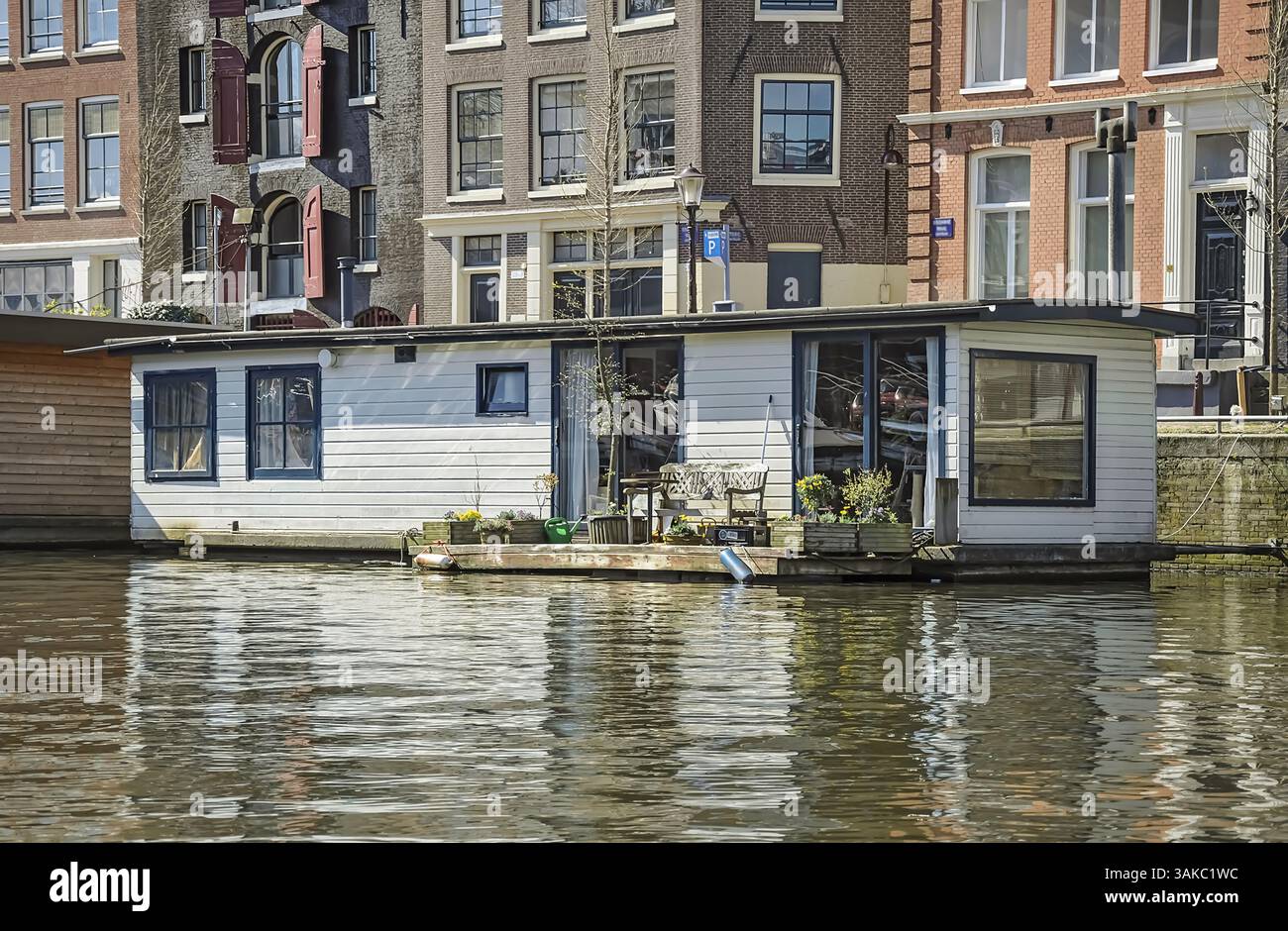 Ein Hausboot, das auf den Grachten von Amsterdam schwimmt, zeigt den einzigartigen niederländischen Wohnstil Stockfoto