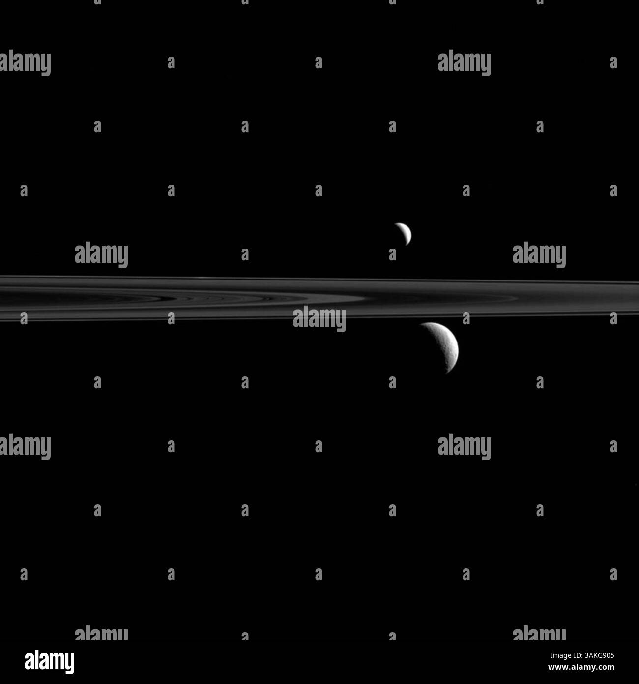 April 2017 - Enceladus Mond. Wissenschaftler haben Wasserstoffmoleküle in wässrigem Material entdeckt, die aus Rissen im Eis von Enceladus, einem Saturnmond, hervorbrechen, und das deutet darauf hin, dass ein Ozean unter dem Eis hydrothermale Quellen hat, die nur fähig sein könnten, Leben zu erhalten. Die Ergebnisse, die auf einer Analyse der Daten des Cassini-Orbiters basieren, sind Gegenstand einer heute in Science veröffentlichten Studie sowie eines NASA-Nachrichtenbriefings. Im Bild: 4. Januar 2016 - Weltraum - Was aussieht wie ein Paar Saturnsatelliten, ist bei genauerer Betrachtung ein Trio. Hier hat Cassini Enceladus gefangen genommen ( Stockfoto