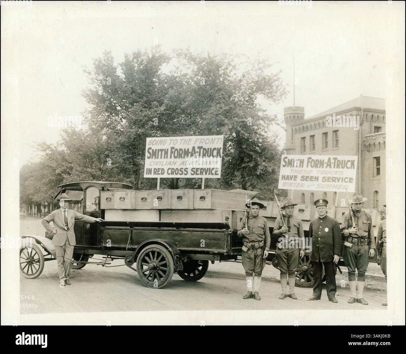 Smith Form-A-Trucks wurden im Ersten Weltkrieg als Teil des zivilen Roten Kreuzes eingesetzt. Dieses Bild zeigt Lkw, die vor der Armory der University of Minnesota geparkt sind, mit Gewehren beladen und von bewaffneten Soldaten bewacht werden. Stockfoto