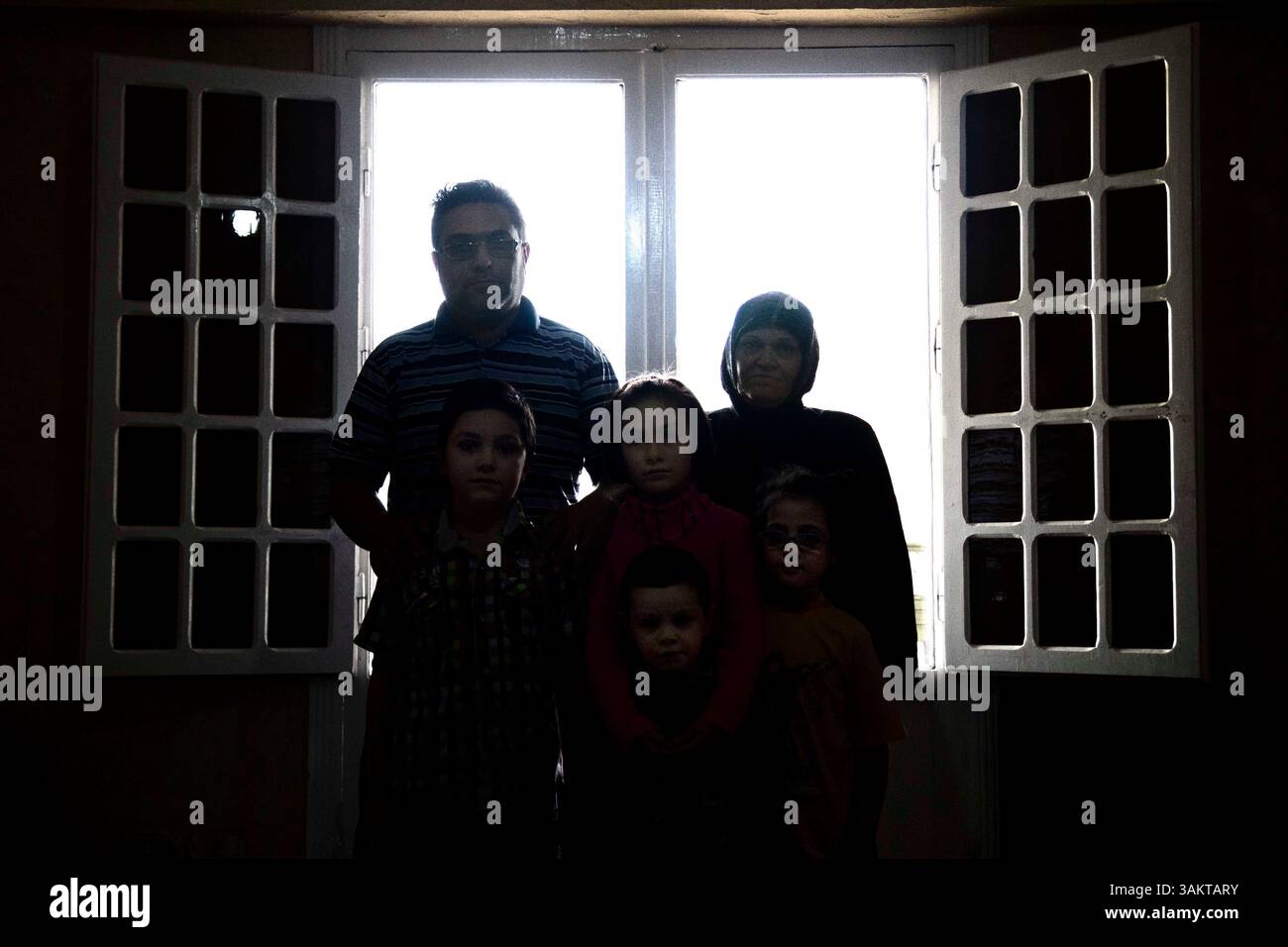 23. November 2013 - Kairo, Ägypten - syrische Familien stehen auf dem Balkon ihrer aktuellen Wohnung in El Obour City, am Stadtrand von Kairo. Er war früher Verkaufsleiter für eine Caffe-Firma in Homs. Sie entkamen dem Krieg Ende 2011 und blieben in den umliegenden Dörfern und Damaskus, wo sie sechs Monate nach dem Verkauf seines Autos und all ihrer Besitztümer verbrachten, um Geld für die Reise nach Ägypten zu bekommen, und leben immer noch von diesen Ersparnissen, obwohl sie versuchen, nicht viel auszugeben. Er erinnert sich daran, dass es zu Beginn während Mursis Mandat viel einfacher war, hier zu wohnen und eine Aufenthaltserlaubnis zu bekommen. Nachdem Mursi ihn verdrängt hat Stockfoto