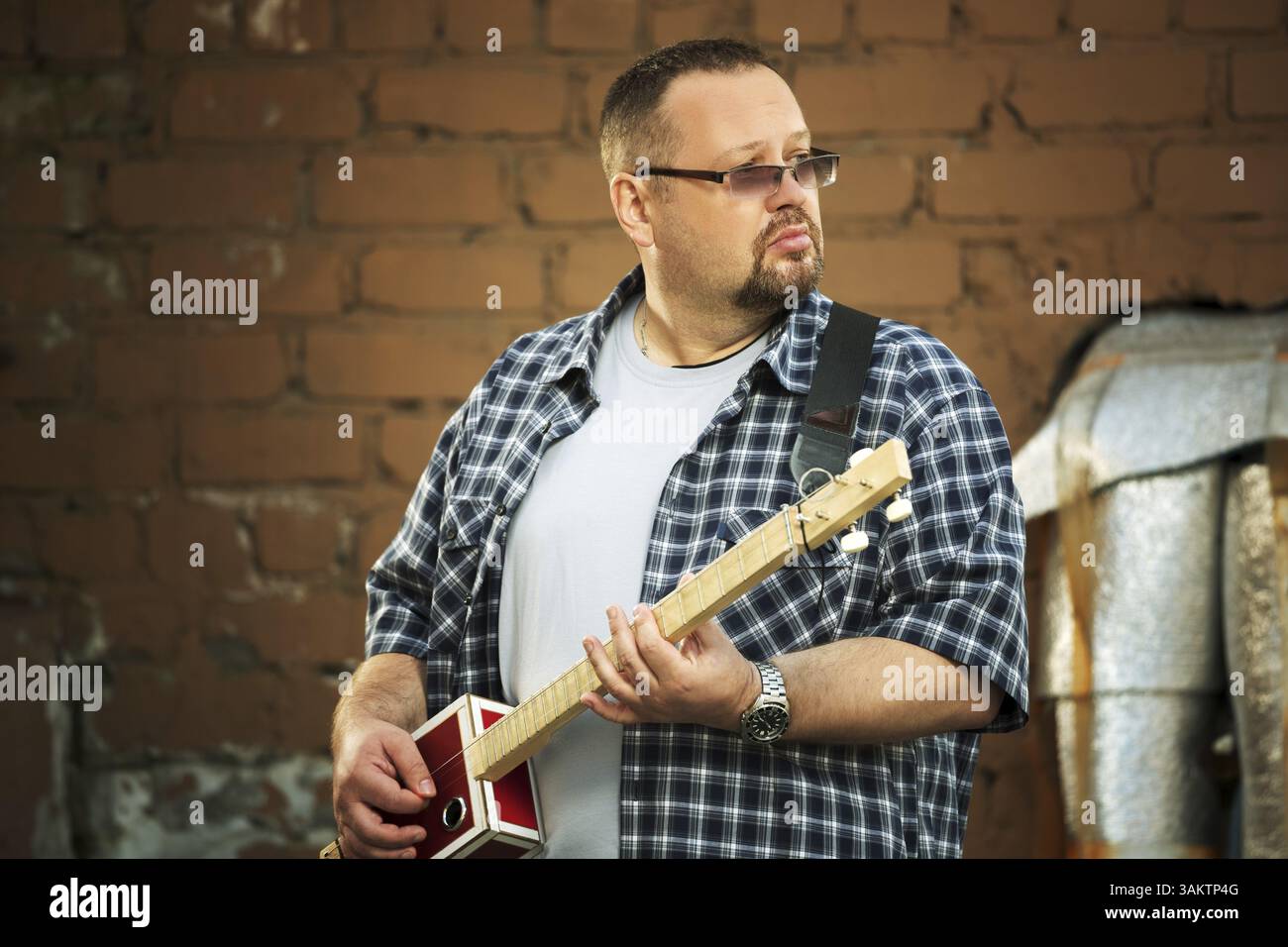 Mann, der seine drei Zeichenfolge Cigar Box Gitarre spielt Stockfoto