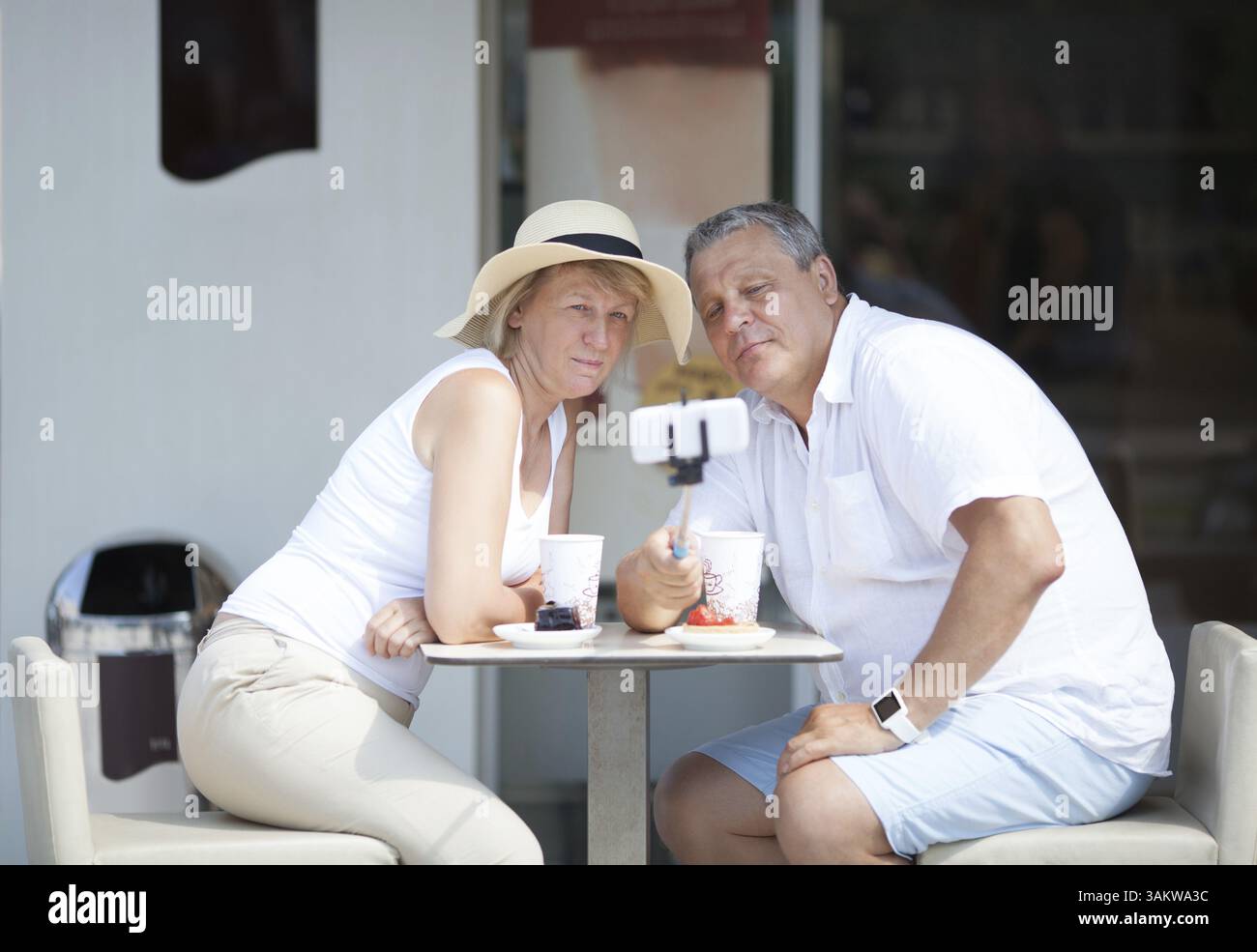 Erwachsene Touristen machen Selfie mit Selfie-Stick in einem Café im Freien Stockfoto