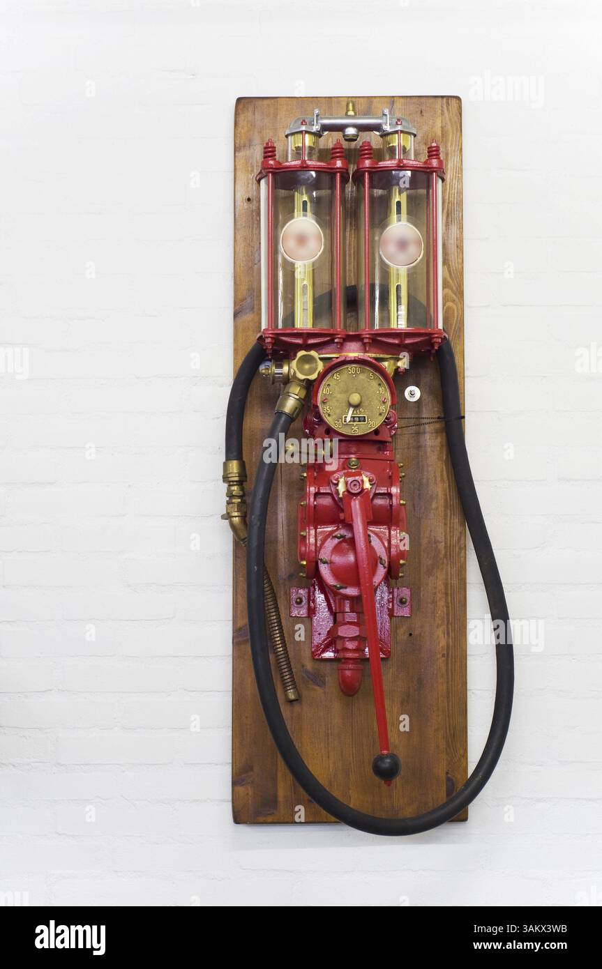 Rote Vintage-Benzinpumpe an der Wand Stockfoto